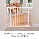 White baby gate in a home setting with a dining table and chairs in the background.